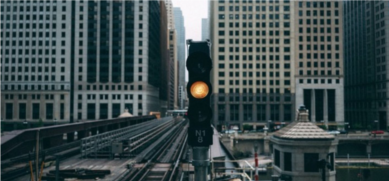 Amber traffic light over city tracks, the Amber metaphor